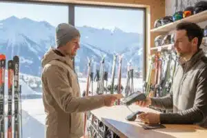 Banque en ligne : 250€ offerts avec cette carte qui assure vos séjours au ski ! homme en train de payer son équipement de ski avec une carte bancaire gold